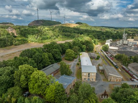 Industriegelände am grünen Piesberg, Osnabrück, mit Windkraftanlagen und historischer Architektur.