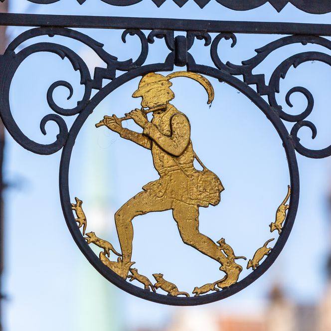Schild am Rattenfängerhaus zeigt den Rattenfänger von Hameln