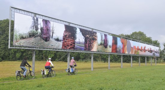 Tre cyklister passerer en kunstobjekt, © TMN / Thorsten Brönner