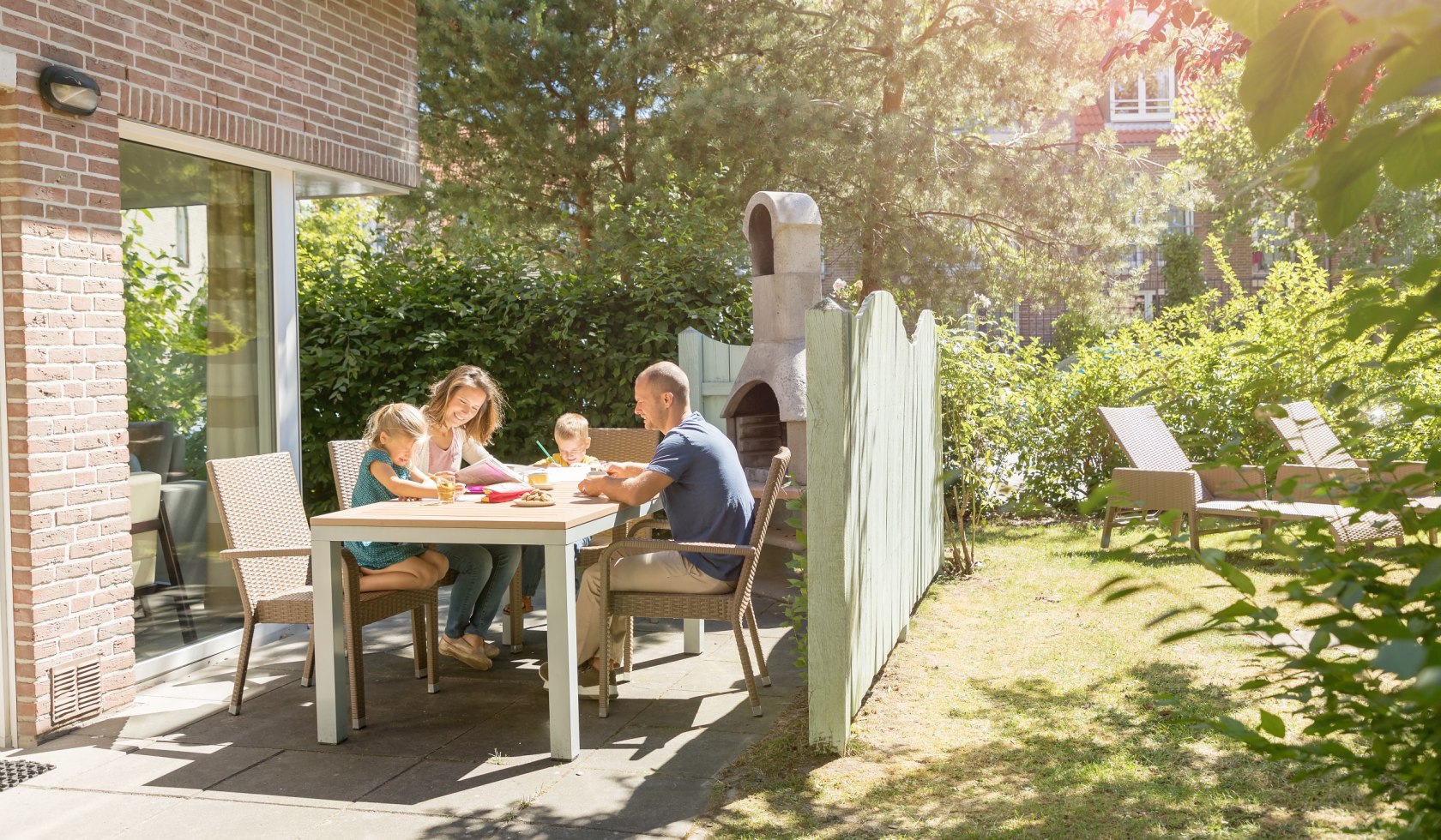 Familien sidder på terrassen foran feriehuset., © Center Parcs