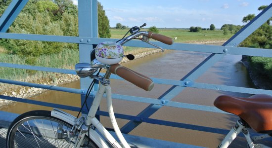 Se fra Amdorf-broen i forgrunden en cykel, © Ostfriesland Tourismus GmbH / www.ostfriesland.de