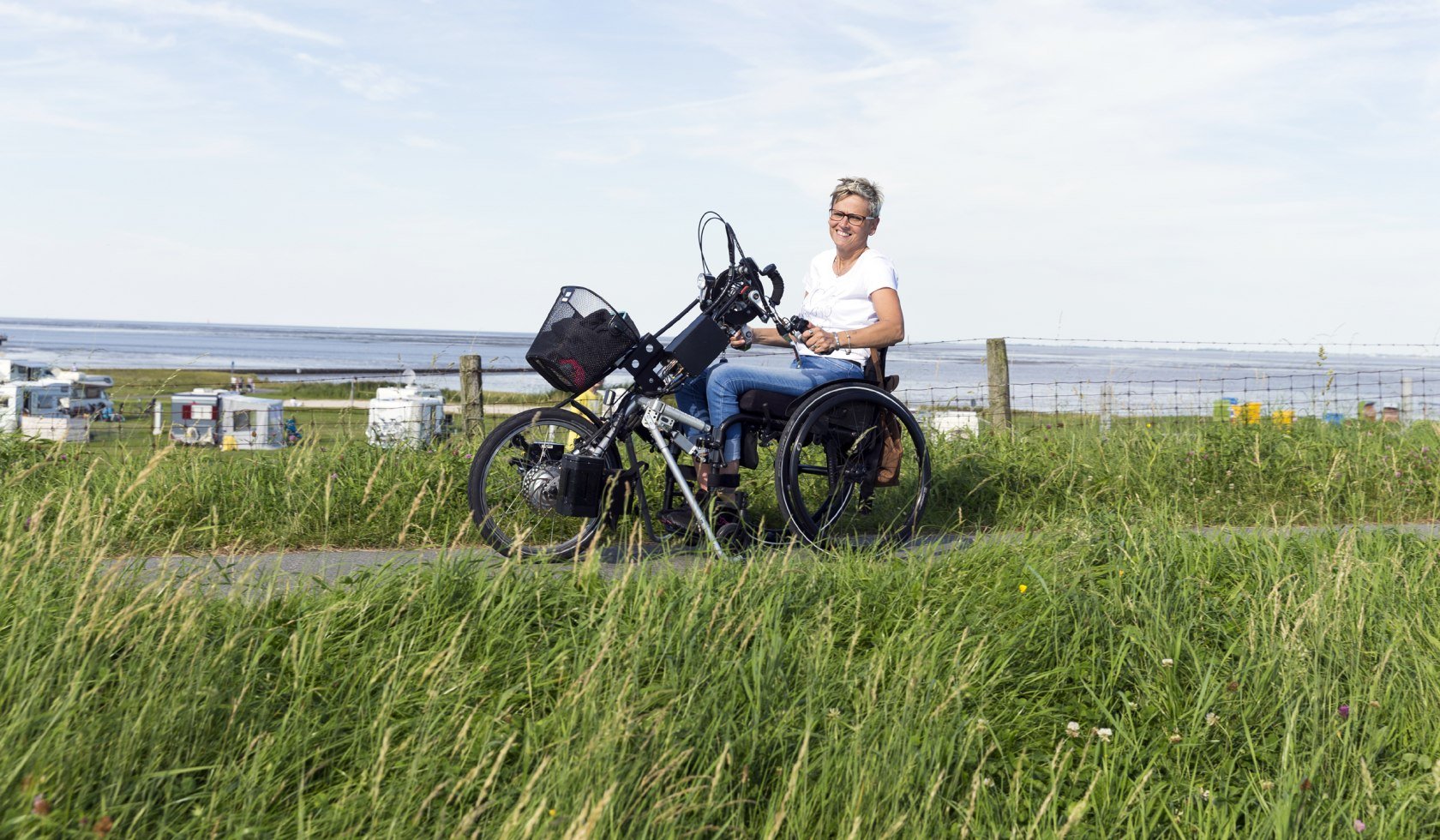 Kvinde med håndcykel på den barrierefri strandpromenade, © Tourismus-Service Butjadingen GmbH &amp; Co. KG