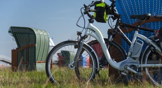 Ebikes læner sig på en strand stol, © Cuxland-Tourismus / Bernd Otten Ebikes læner sig på en strand stol, © Cuxland-Tourismus / Bernd Otten