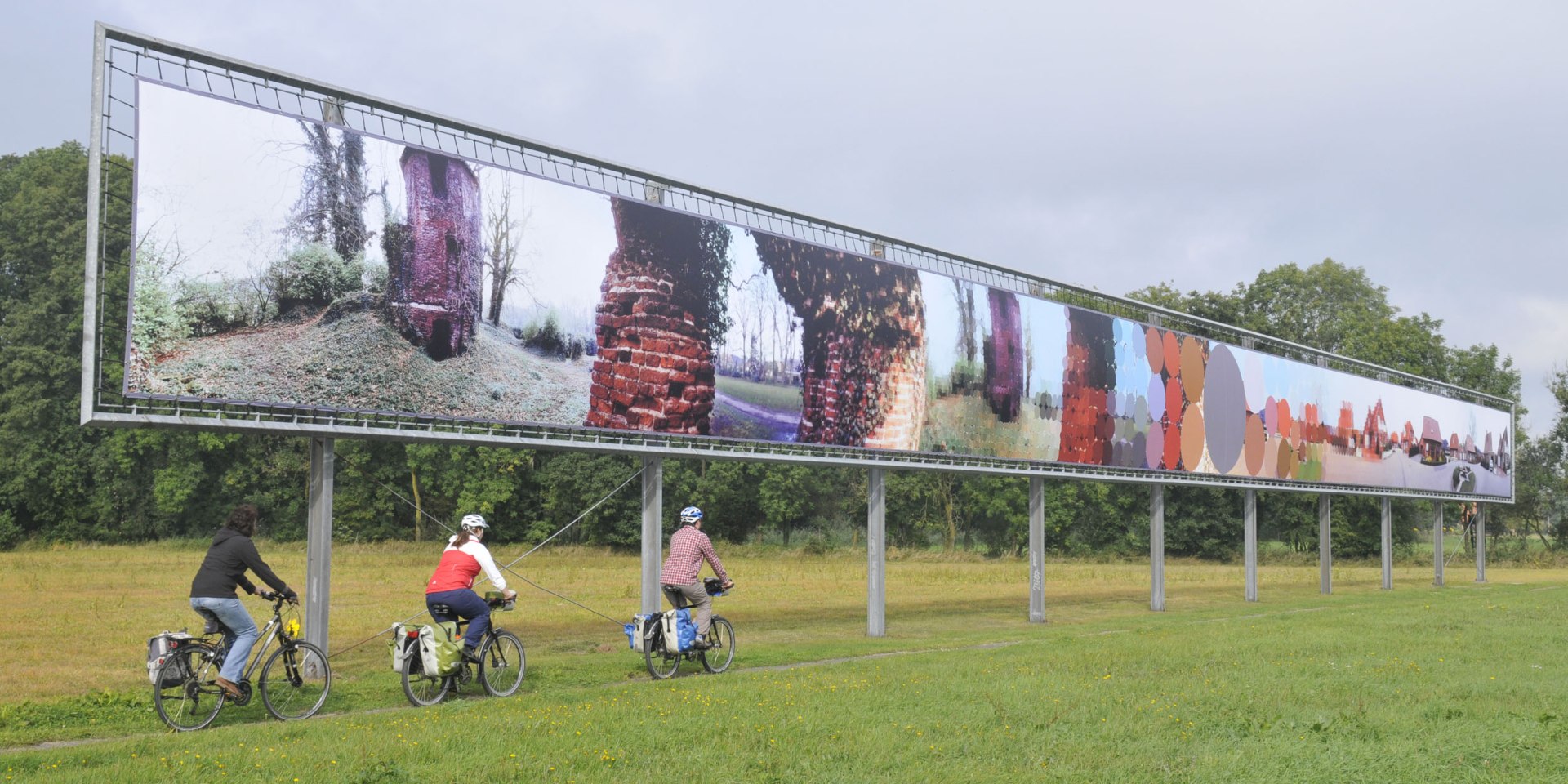 Tre cyklister passerer en kunstobjekt, © TMN / Thorsten Brönner